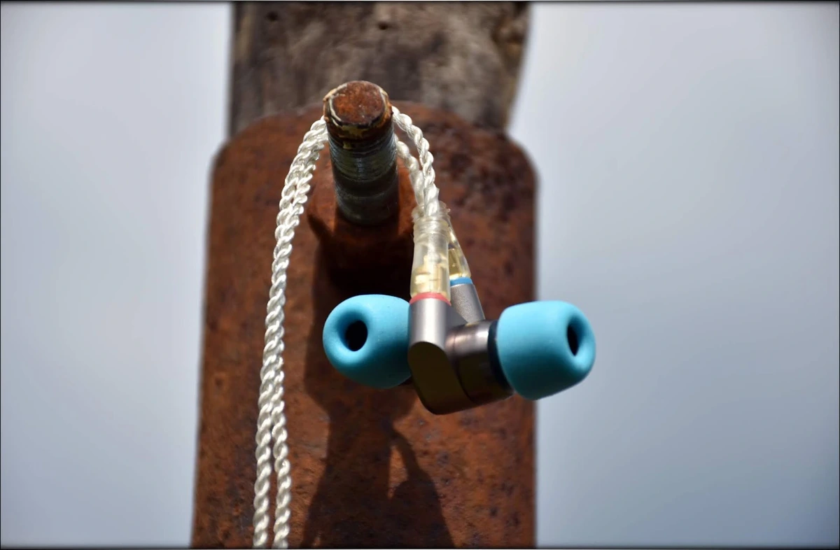 Tin T2 with blue foam tips, seated on a metal construction, rusty and textury surface